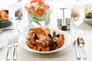 Table setting with a mussels and lobster course dinner in center